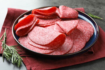 Slices of delicious sausage served on grey table, closeup