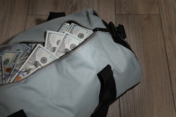 Bag full of dollar banknotes on wooden background, closeup