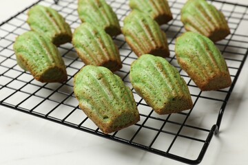 Tasty matcha madeleine cakes on white table, closeup