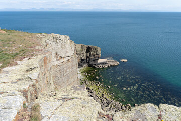 Welsh coast path Landmark, Slate Toll Point, Trwyn Llech-y- Doll, on Cilan Head, Lleyn Peninsular, Wales, UK, with views across the sea to mountains in the distance.