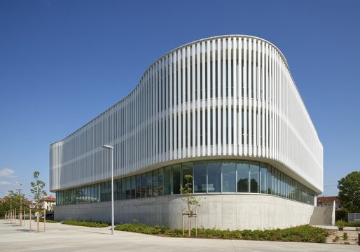 Modern White Building Architecture - Exterior View of a Stylish Office or Library with Curved Facade and Vertical Louvers