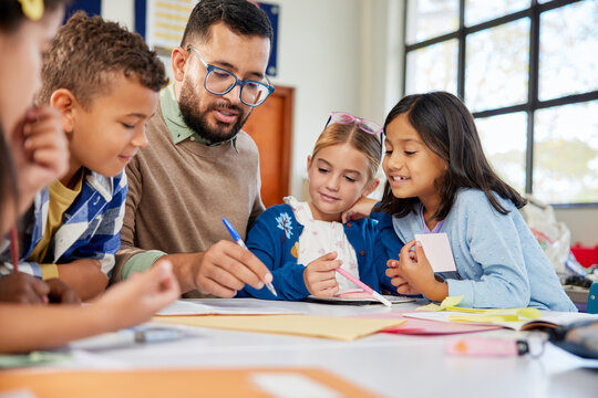 Teacher checking children homework at school - Powered by Adobe
