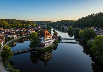 Obraz premium Aerial view of historic house on a small river island surrounded by European town and forest.
