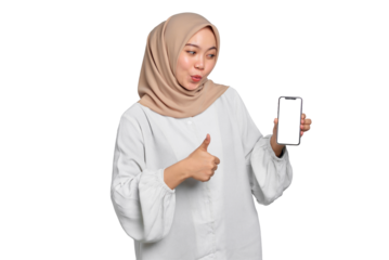 Amazed young Asian Muslim woman showing mobile phone blank screen recommending App and gesturing thumbs up isolated on transparent background