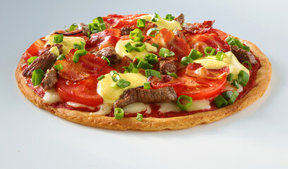 Pizza mit RInderfilet Tomaten Fruelingszwiebeln und Kaese mit Bacon auf weissem Fond, Italien, Tomaten, isoliert, 