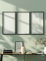 Three blank picture frames above modern desk with home decor and shadow play photo