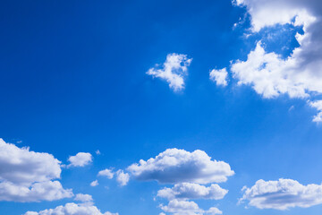 Blue sky and clouds in sunny day. Clear blue sky with faint, fluffy white clouds scattered lightly.