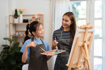 Creative bonding activity: Mother and daughter painting together in a cozy environment