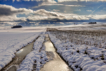 Zamarznięta polna droga na ośnieżonym polu. Pomorze zachodnie