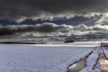 Zamarznięta polna droga na ośnieżonym polu. Pomorze zachodnie