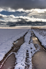 Zamarznięta polna droga na ośnieżonym polu. Pomorze zachodnie