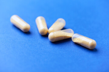 Coenzyme Q10 capsules. Antioxidants. Concept for a healthy dietary supplementation. Bright paper background. Soft focus. Close up. Copy space.	