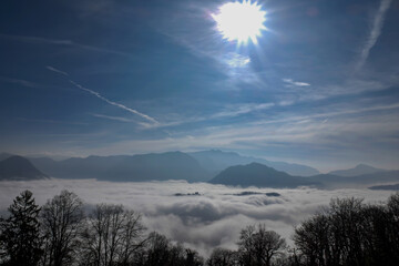 Mountain Peak Above Cloudscape and Bare Tree in a Sunny Day in Lugano, Ticino in Switzerland.