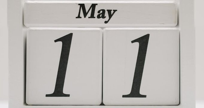 Wooden calendar with interchangeable blocks showing the date May. Simple and minimalist design for desk or home decor. Wooden Calendar Display Showing May Date in Black and White
