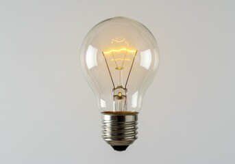 Incandescent light bulb glowing on a white background in studio shot