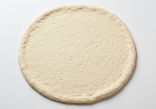 Uncooked pizza dough round on white surface ready for toppings