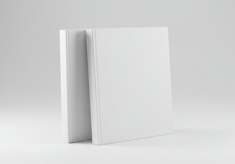Two blank white books standing on a white surface in a studio setting