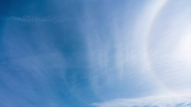 タイムラプス　青空に流れる薄い雲と太陽の周りにできた虹