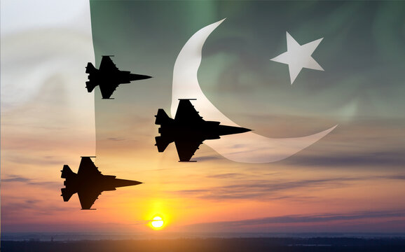 Silhouette of military aircraft against the sunset with Pakistan flag