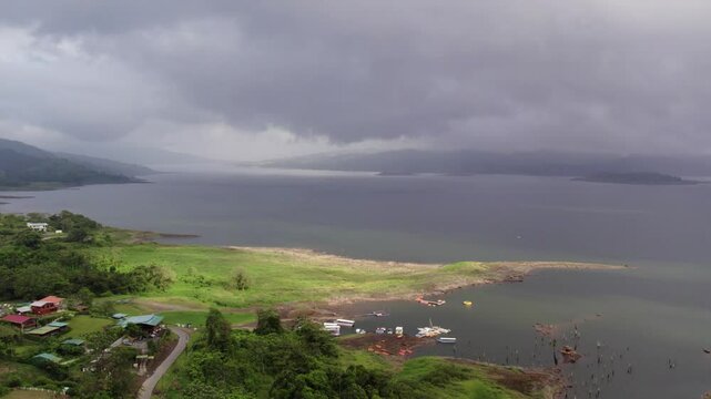 Aerial view of Lake Arenal from shoreline of El Fosforo with dark clouds