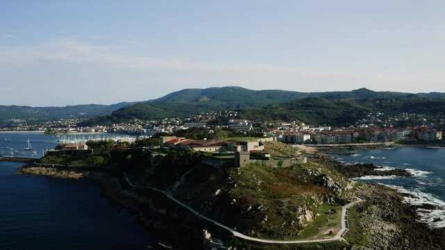 Aerial View Of Baiona City In Galicia Spain, Coastal Landscape With Hotel On Top Of Hill and Town In The Distance