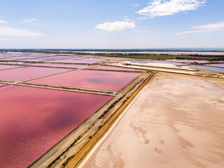 Aigues-Mortes, Camargue, France,  the largest mediterranean salt marshes in beautiful pink and red colors, for production of table salt, and a mount of white salt  