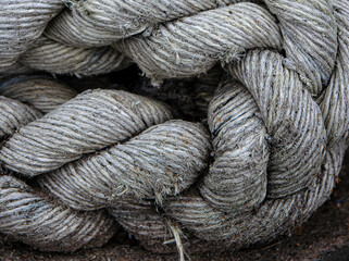 Closeup of thick braided marine rope. Coarse texture and rugged natural fibers used in shipping...