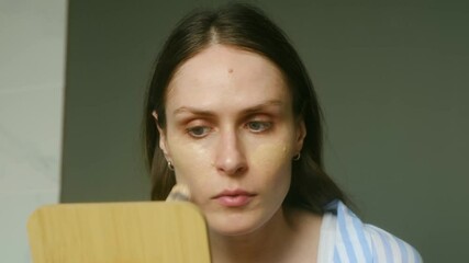 Beautiful woman in plaid shirt applies foundation cream with brush before mirror. Makeup routine at home against dark wall showcases flawless foundation cream application for perfect makeup finish.  - Powered by Adobe