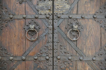 Old wooden door with ornate metals handles