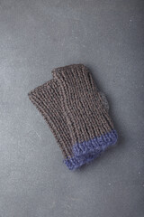 Blue mohair and grey acrylic yarn knit mittens on grey background. Knitted clothes, accessories. Copy space