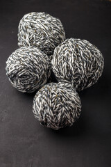 Melange grey white yarn balls on black background, close up shot