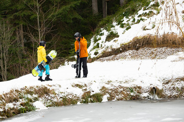 Friends preparing for an adventure in the snowy mountains, eagerly ready with snowboards and...