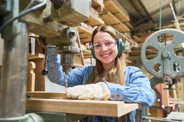 Young woman working with machinery in a busy lumberyard environment