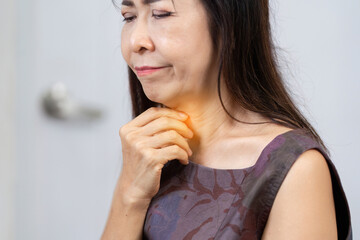Senior woman experiencing throat discomfort and health concerns