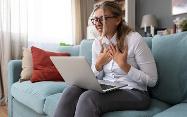 Young freelance business woman having video call conference on laptop computer while sitting and...