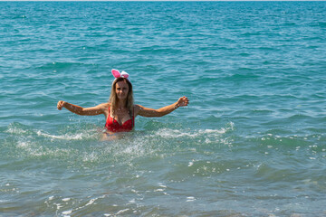 Christmas Sea Splash: Girl in Red Swimsuit with Santa Hat