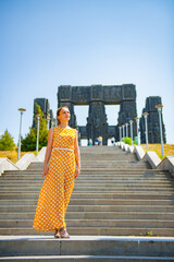A girl stands at the stairs at the monument to the chronicles of Georgia