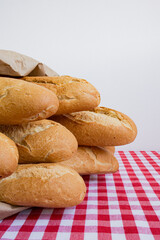 Fresh baguettes on red checkered tablecloth in rustic kitchen setting