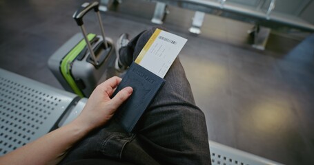 Crowded International Airport Terminal: Passenger with Suitcase, Passport and Plane Ticket Sitting...