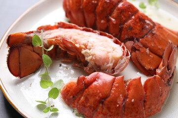 Delicious tails of boiled lobsters served on grey table, closeup
