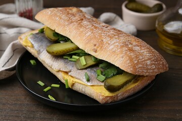 Tasty sandwich with herring, pickles, green onions and parsley on wooden table, closeup