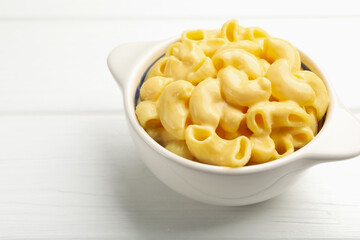 Delicious macaroni and cheese on white wooden table, closeup