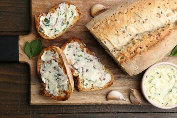 Tasty bread with garlic, herbs and oil on wooden table, top view