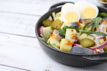 Delicious salad with herring, egg and vegetables on white wooden table, closeup. Space for text