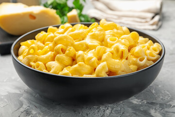 Delicious pasta with cheese sauce in bowl on grey table, closeup