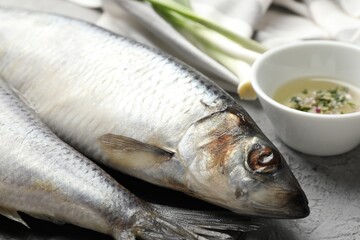 Salted herrings and spices on grey table, closeup