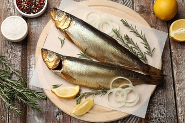 Smoked herrings and spices on wooden table, flat lay