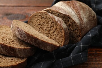 Pieces of fresh bread on wooden table, closeup