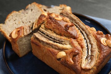 Cut banana bread with nuts on table, closeup