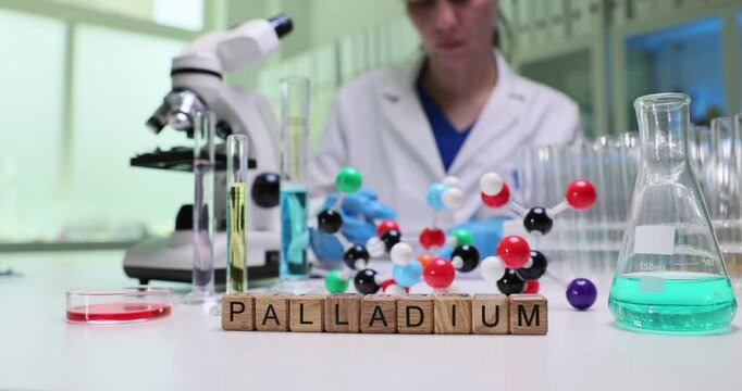 A scientist examines palladium molecular structures in a lab, showcasing modern research techniques.